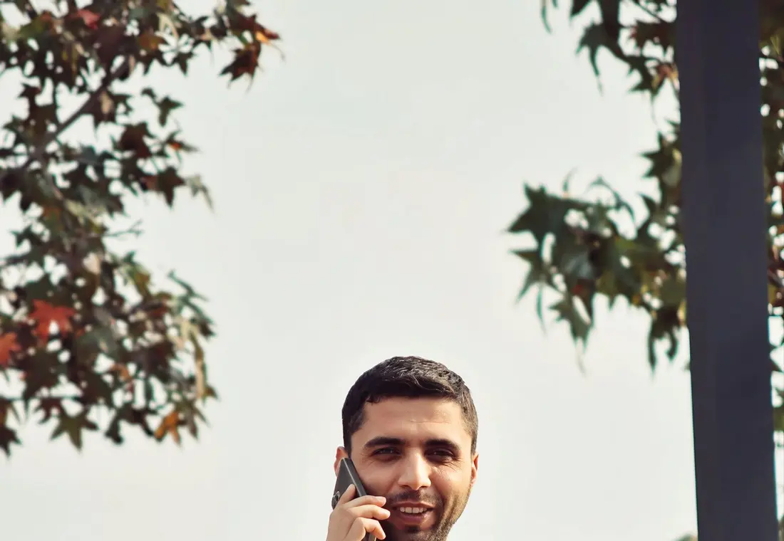A man taking a phone call outdoors